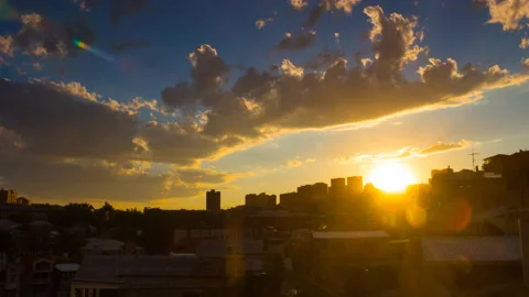 Timelapse of dramatic sunset over cityscape with clouds, sun. Stock Footage 169844791