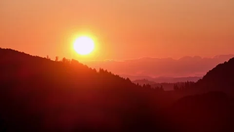 Timelapse of a dramatic sunset over a mountain ridge with vibrant clouds Video stock 317153941