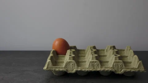 Timelapse of Egg Carton Replenishing and Depleting on Gray Table Stock Footage 280743979