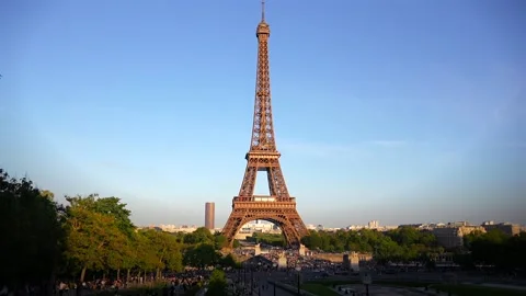 Timelapse of Eiffel Tower at sunset with greenery and blue sky Stock Footage 311321761