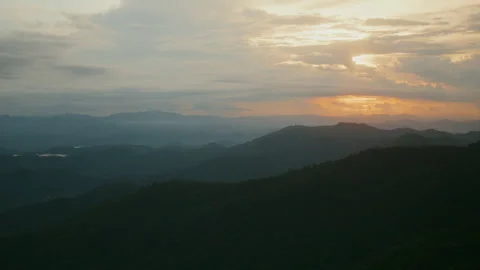 Timelapse of the evening clouds moving in the sunset sky above the mountains Stock Footage 261490399