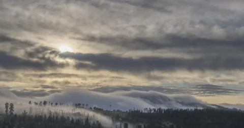 Timelapse of evening sun rays emerging through the cold foggy clouds in the Stock Footage 155082736