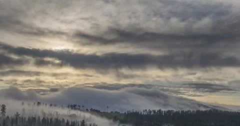 Timelapse of evening sun rays emerging through the cold foggy clouds in the Stock Footage 222512818