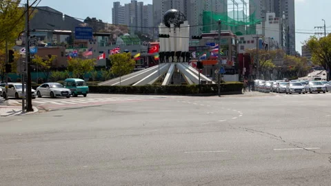 Timelapse famous Busan statue surrounded by flags and cars Stock Footage 117208599