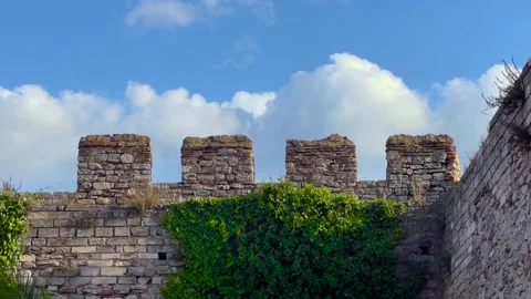 Timelapse of fast clouds moving behind ivy-covered fortress crenellations Stock Footage 346484260