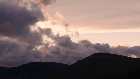 Timelapse of fast moving clouds over mountain top during sunset. Dramatic clo Stock Footage 91446226