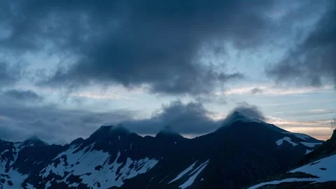 A timelapse of fast moving clouds over mountain peaks at sunset in Switzerland Stock Footage 302840992