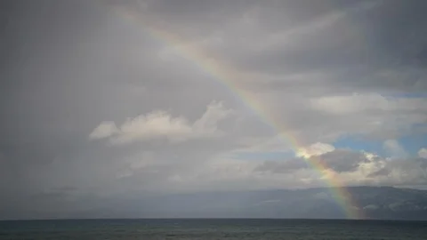 Timelapse of Fast-moving Sunrise Clouds and Rainbow Over the Pacific from Maui Stock Footage 128989934