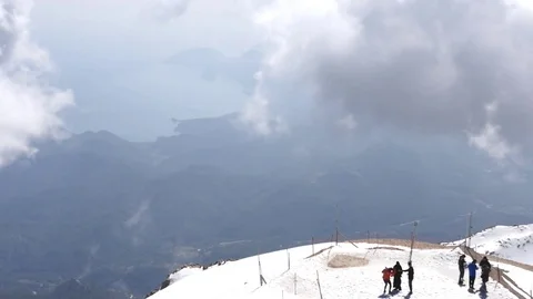 Timelapse of fastly moving clouds above the mountain and people on the terrace Stock Footage 74106067