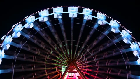 Timelapse of Ferris wheel with multi-colored illumination against night sky Stock Footage 171479054