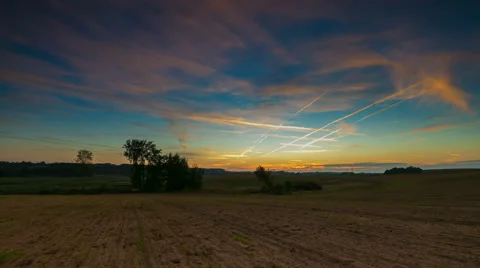 Timelapse of fields under sunset sky with chemtrails 動画素材 58932873