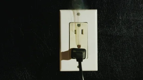 Timelapse: Fire in a dual-socket US type. Streams of black smoke come from the Stock Footage 74592739