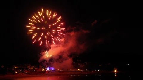 Timelapse of a firework from a beach over a coastal town. Progressive zoom - HD Stock Footage 112660233