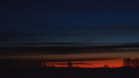 Timelapse of floating clouds before dawn over silhouettes of trees Stock Footage 120418152