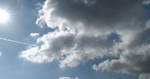 Timelapse of fluffy clouds in the blue sky on a sunny day, contrail Stock Footage 253434954