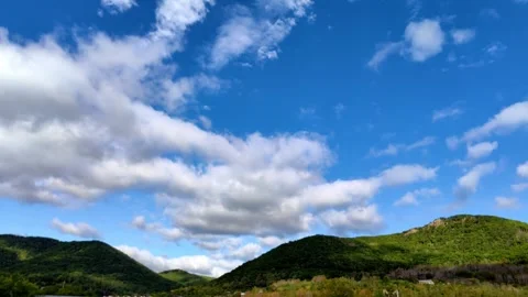 Timelapse fluffy clouds moving over green rolling hills. Vídeo Stock 336537571