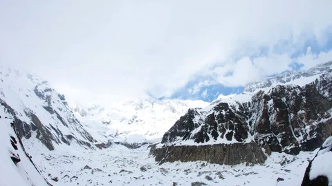 Timelapse of fluffy clouds moving quickly across sky above snowy mountains Stock Footage 124237926