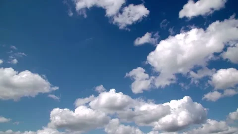 Timelapse of fluffy white clouds moving across bright blue sky on a sunny day 스톡 동영상 342994935