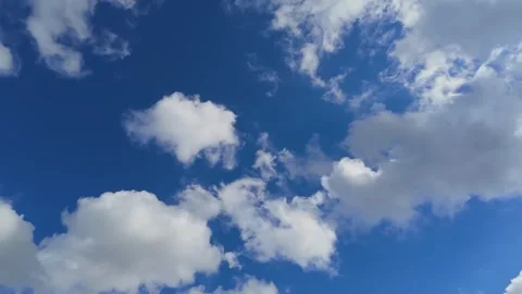 Timelapse of fluffy white clouds moving across bright blue sky on a sunny day 库存影片 342994949