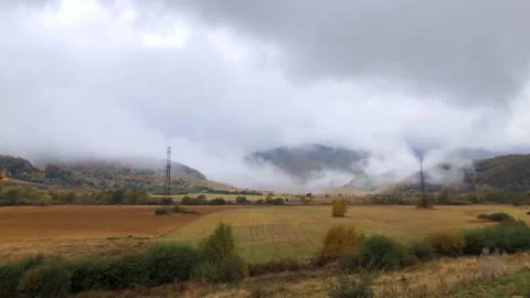 Timelapse with flying clouds enveloping the mountains with swirls. Stock Footage 255932348