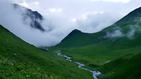 Timelapse of fog and clouds rolling over mountain green valley and winding River Vídeos de archivo 65775453