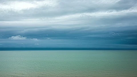 Timelapse footage of a beach with clear blue water and moving clouds above Stock Footage 256133527