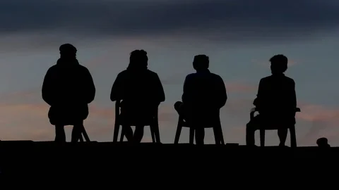 Timelapse of four young men sitting on roof at sunset. Video stock 139845987