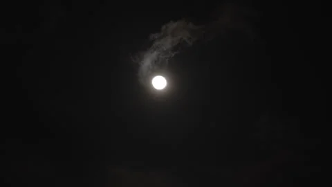 Timelapse of a full moon illuminating the night sky as dramatic clouds Stock Footage 341483241