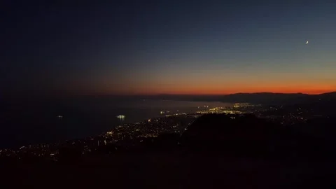 Timelapse of Genoa city as seen from Mount Fasce at sunset, with ships and moon Stock Footage 312097975