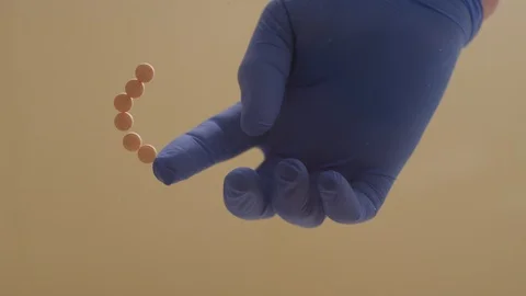 Timelapse of a gloved hand spelling out "get high" with painkiller pills Video stock 127227648