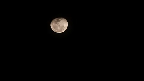 Timelapse of a glowing moon moving across a dark night sky 動画素材 332721832