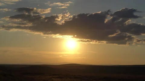 Timelapse Gobi Desert sunset beneath partly cloudy sky arid dunes warm dusk glow Video stock 339568500