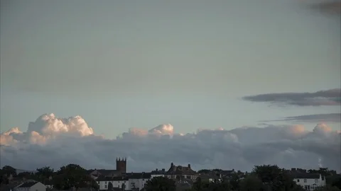 Timelapse of Golden Billowing Clouds at Sunset with Small Countryside Town Below Stock Footage 84449128