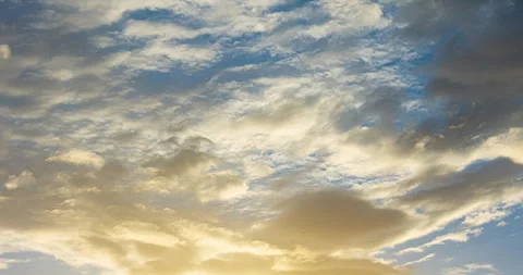 Timelapse of golden fluffy clouds moving on the blue sky in sunset Stock Footage 287789970