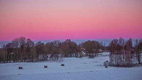 Timelapse of gradient red sky turning orange in snow filled scene with Stock Footage 232969578