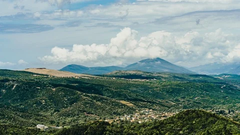 Timelapse green mountains and thick clouds of little houses in the mountains Stock Footage 129677514