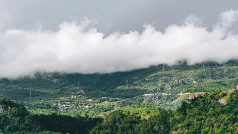 Timelapse green mountains and thick clouds of little houses in the mountains Stock Footage 129677544