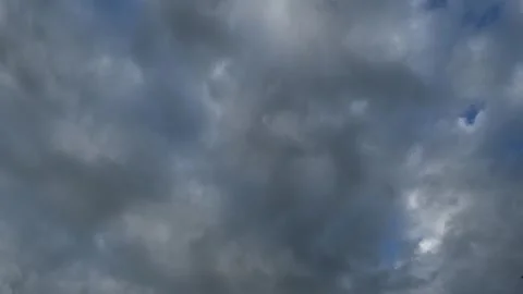 Timelapse of grey and white summer clouds drifting across a blue sky Stock Footage 341835237