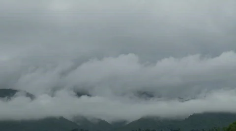 Timelapse of grey clouds rushing in front of a mountain Video stock 558981