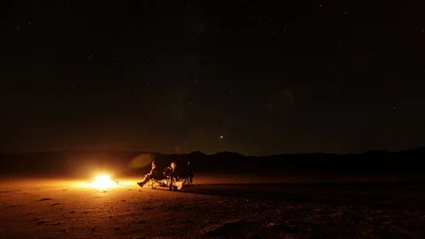 Timelapse of a group sitting by a fire in the desert Stock Footage 92105458