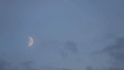 Timelapse of the half moon disappearing behind the clouds Stock Footage 208373158