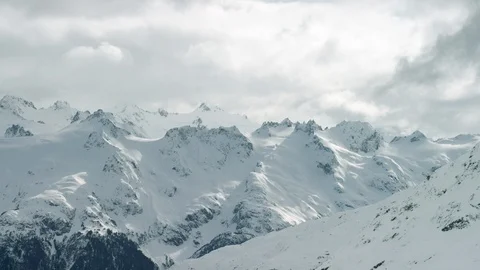 Timelapse of heavy clouds travelling across sky above snowy mountain peaks Stock Footage 124238309