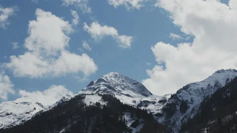 A timelapse of a high mountain with a snow cap on the background of the sky and Stock Footage 227063683
