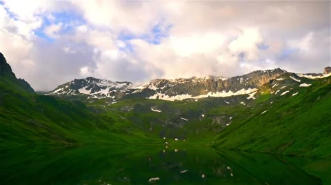 Timelapse of High Snowy mountains with sunset clouds and peaceful mirror lake 스톡 동영상 65774459