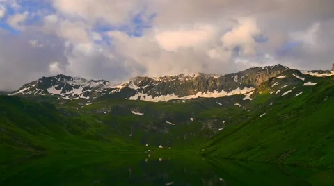 Timelapse of High Snowy mountains with sunset clouds and peaceful mirror lake Stock Footage 65992755