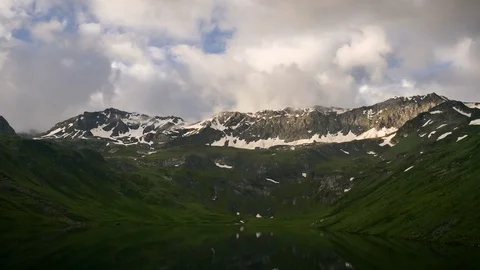 Timelapse of High Snowy spring mountains with sunset clouds and peaceful mirror 스톡 동영상 71197223