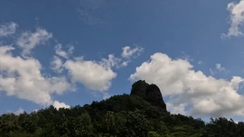 Timelapse of hilly scenery with soft white clouds moving fast in the daytime Video stock 320055619