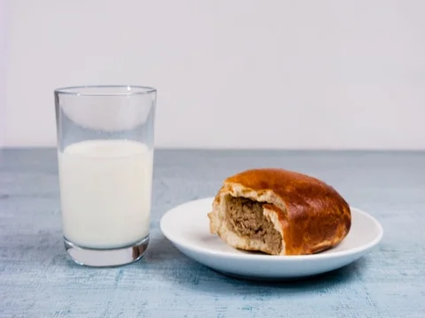 Timelapse of homemade meat pie and glass of milk on a wooden kitchen table Stock Footage 80671563