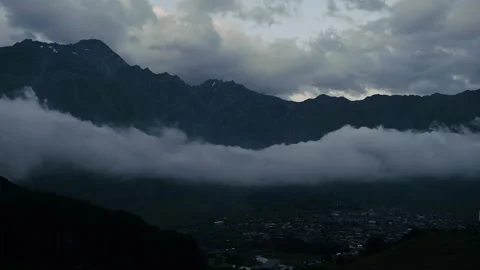 Timelapse of huge low cloud moving above Kazbegi village in Caucasus Mountains Video stock 254763211