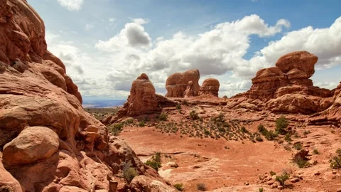 Timelapse-Hyperlapse of fluffy clouds over red rock formations Video stock 154564960